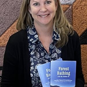 Dr Deborah Early posing with book "The Art of Nature"