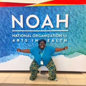 Lateefat posing in front of the NOAH backdrop