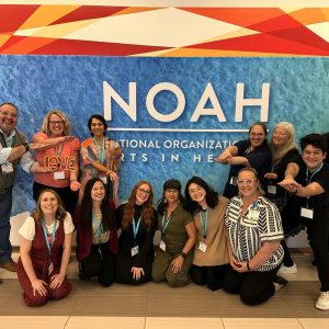 UFCAM alumni at NOAHCON 24 in front of the NOAH banner
